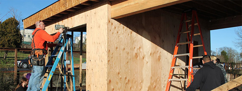 Clover Park's Dan Smith, left, and a group of his Residential Construction and Sustainable Building Science students work on the SHED in UW Tacoma's Giving Garden.