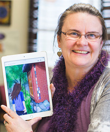 Jennifer Quinn poses with one of her projects, an illustrated young adult novel that involves math puzzles.