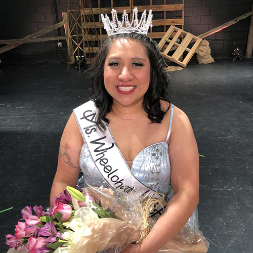 Erica Myron, wearing tiara and sash, carrying flower bouquet, shortly after being named Ms. Wheelchair USA.