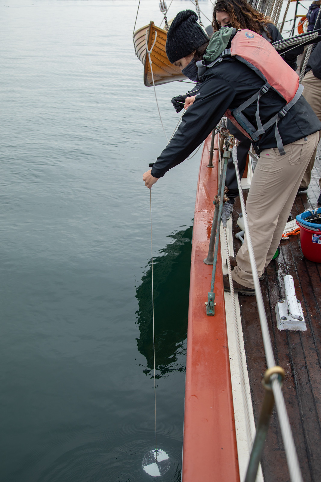 Secchi disk being lowered over side of Adventuress into Commencement Bay