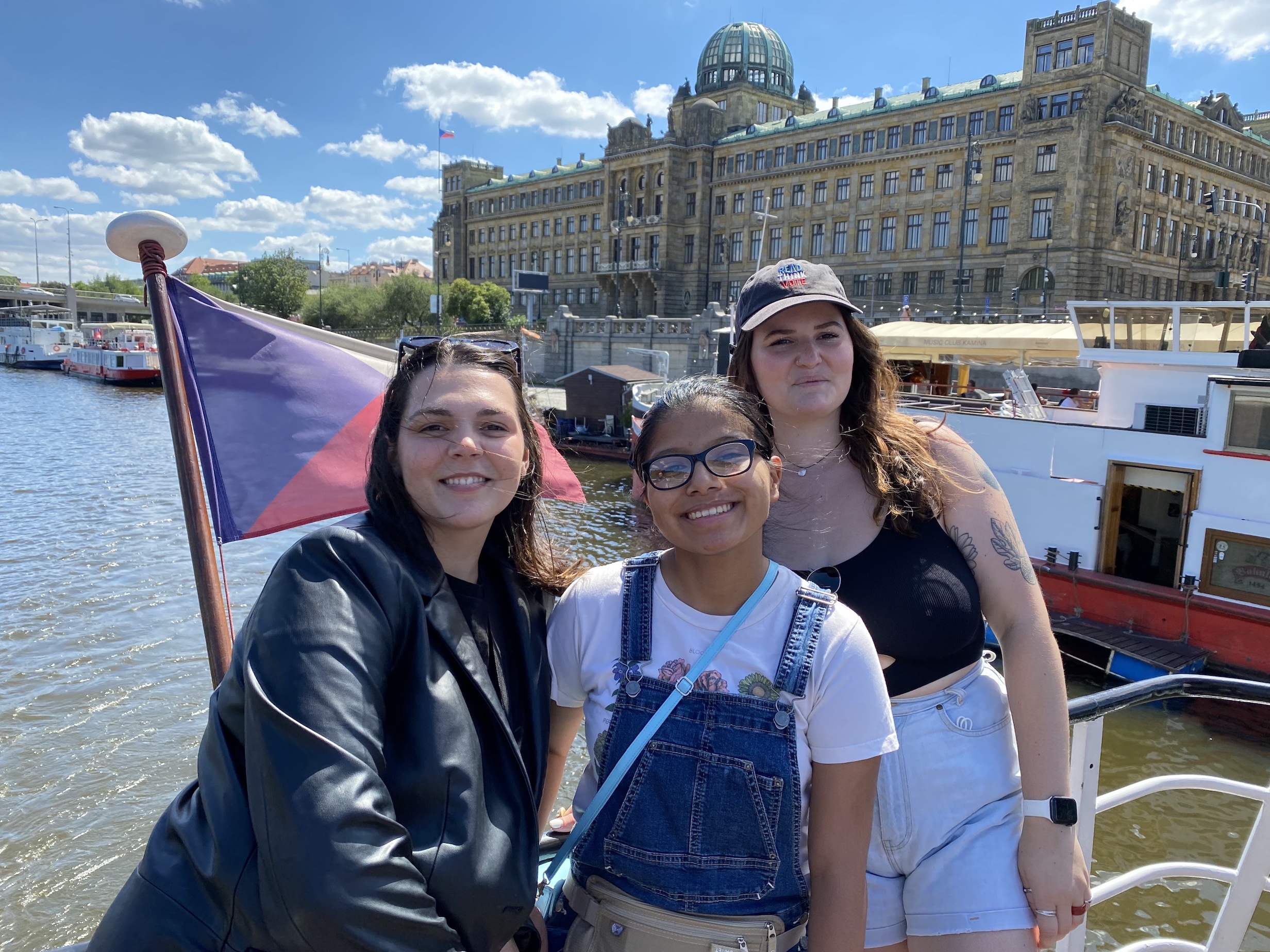 3 female students smiling on a boat