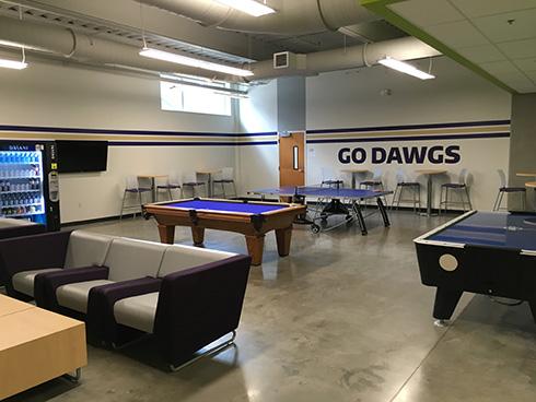 Photo of UWY Game Room showing TVs, pool table, ping-pong table, couches.