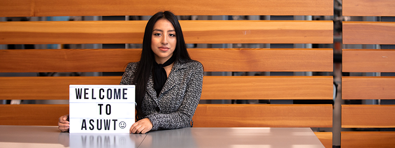 Maria Crisostomo, '19, posing with sign reading "Welcome to ASUWT"