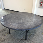 Round table with silver and black swirled surface top and black legs