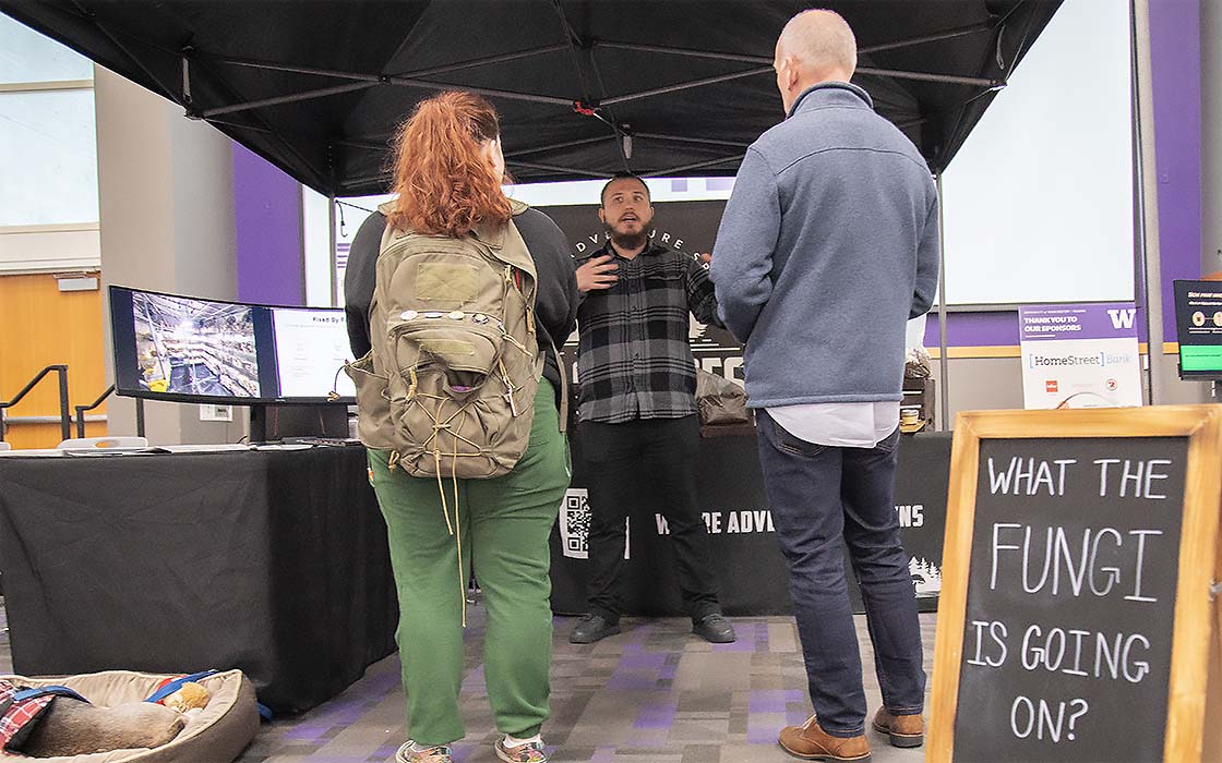 Nathanael Engen explains his company Black Forest Mushrooms to visitors at the 2023 VIBE Business Plan Competition trade-show round.