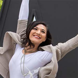 Isabell Murray, '19, B.A. Law & Policy, executing balletic leap in front of UW Tacoma steel W.