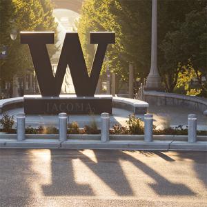 UW Tacoma steel W backlit by the sun, with shadow stretching into the foreground