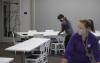 UW Tacoma staffers shifting classroom tables and chairs into new configuration.