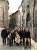 A group of students taking a group picture on a narrow city street