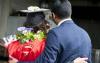 View of backs of two 2013 UW Tacoma graduates, one displaying a red S logo on back of Commencement sash